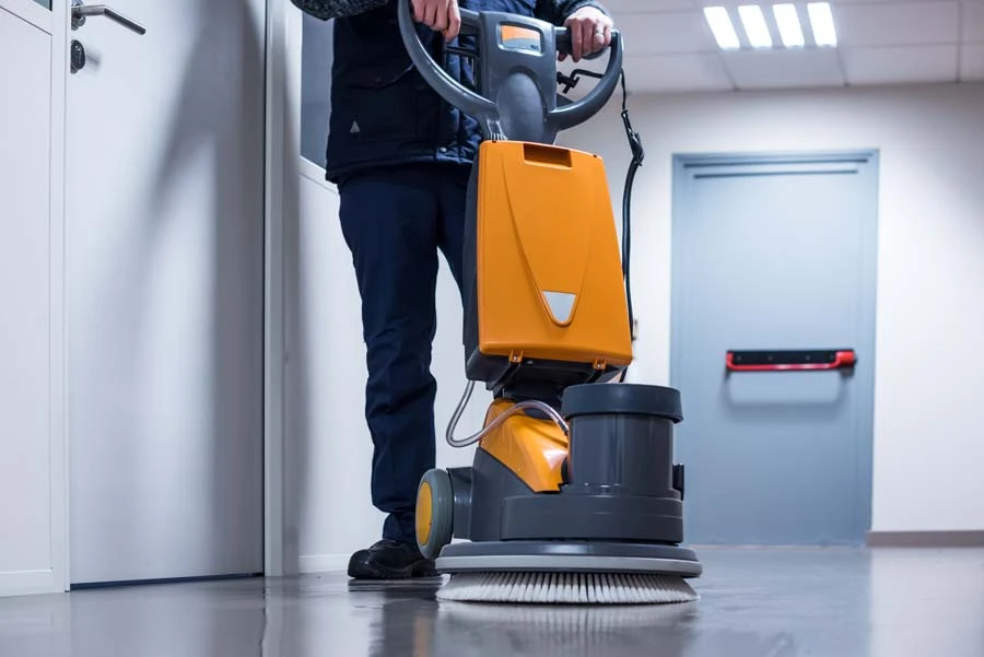 Nettoyage professionnel d'un sol carrel&eacute; dans un environnement int&eacute;rieur avec un agent d'entretien utilisant une monobrosse