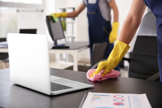 Espace de travail de bureau avec produits de nettoyage professionnel dispos&eacute;s sur un plan de travail blanc