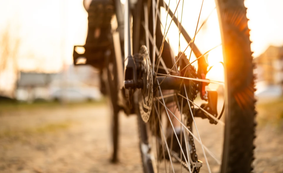 Agent de nettoyage à vélo professionnel dans un quartier urbain nantais, portant des sacoches de travail adaptées (sacoches professionnelles noires ou grises) et transportant du matériel de nettoyage (aspirateur à batterie, équipement d'entretien) sur son vélo, positionné dans une rue résidentielle ou devant un immeuble. L'image doit montrer clairement l'aspect écologique du déplacement à vélo tout en mettant en avant le professionnalisme du service de nettoyage.